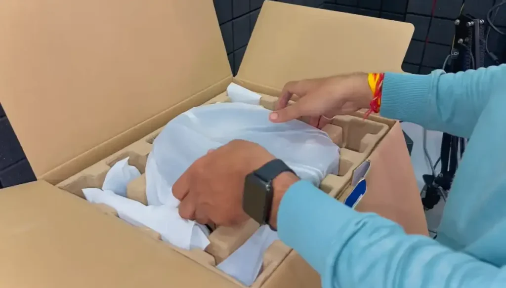 MOZA R5 racing wheel unboxing showing wheel base, steering rim and pedal set inside packaging box